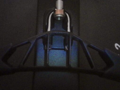 Close-up of a rowing machine handle in low light, with a subtle blue reflection on the metal surface.